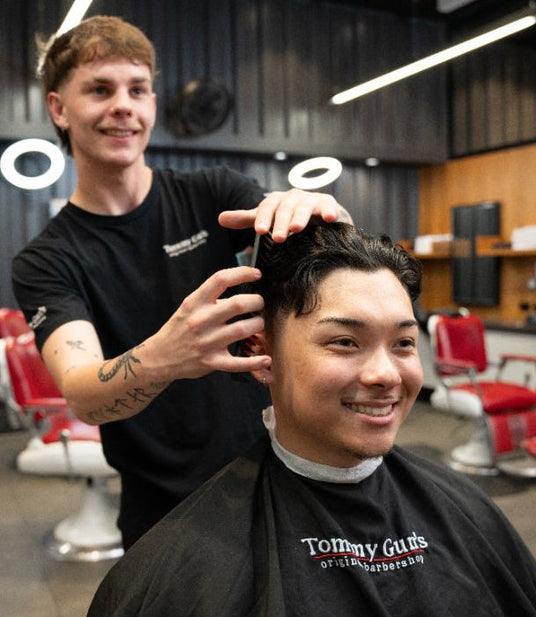 Barber cutting a customer's hair in a salon setting
